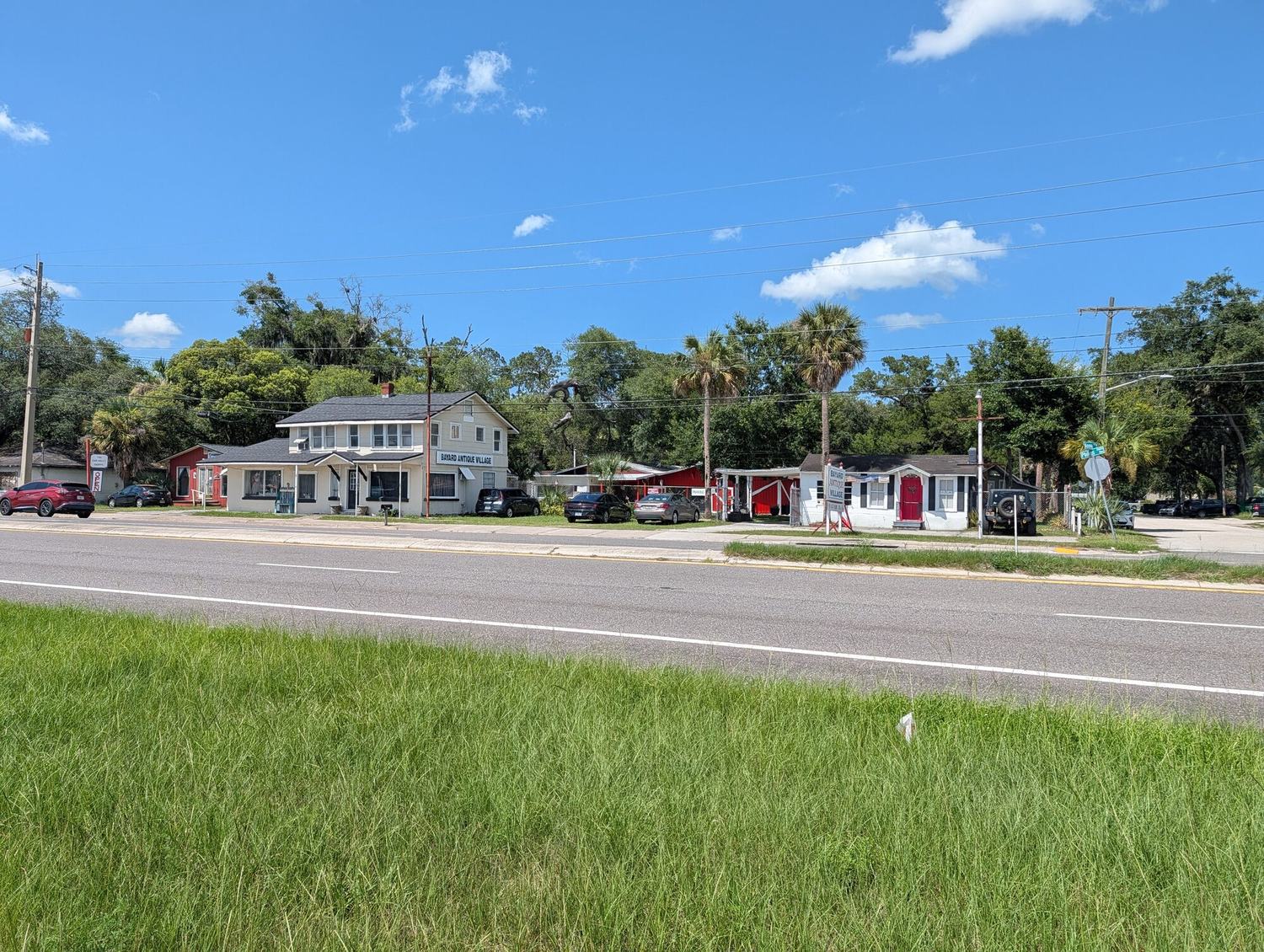 Bayard Antique Village today, seen from Philips Highway: the two-story Main House and the row of former motor-court cabins